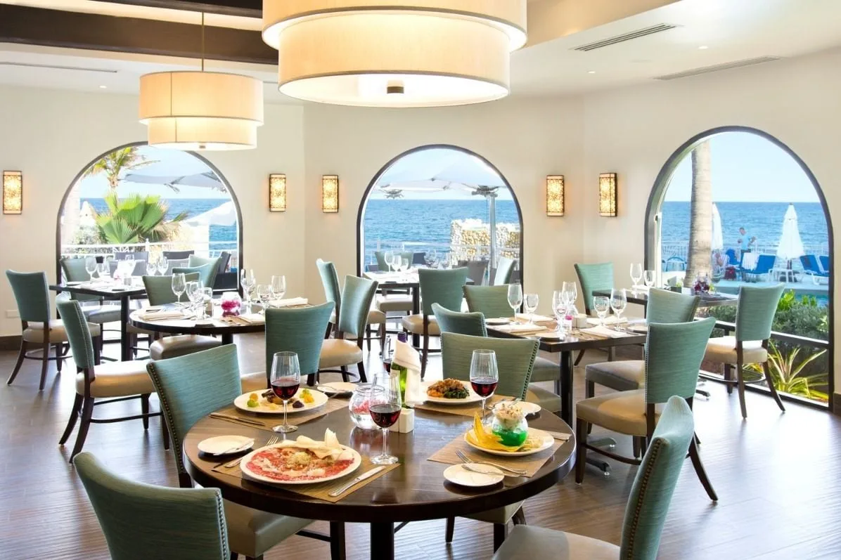 Ocean-view dining room with set tables at Oyster Bay Beach Resort.