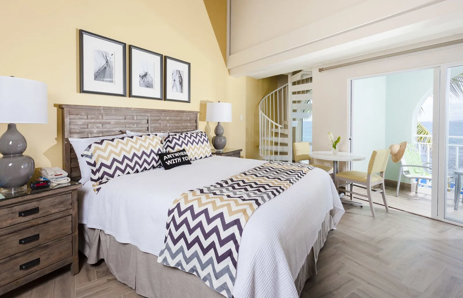 Deluxe Courtyard Loft king bed with balcony doors at Oyster Bay Beach Resort.