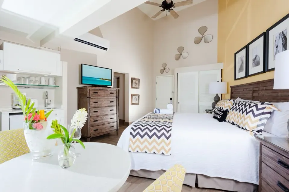 Deluxe Courtyard Loft king bed with kitchenette and dining table at Oyster Bay Beach Resort.