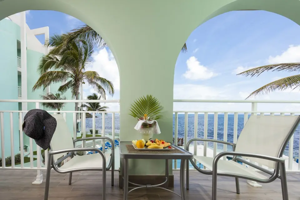 Ocean Front Courtyard Room balcony with chairs and ocean view at Oyster Bay Beach Resort.