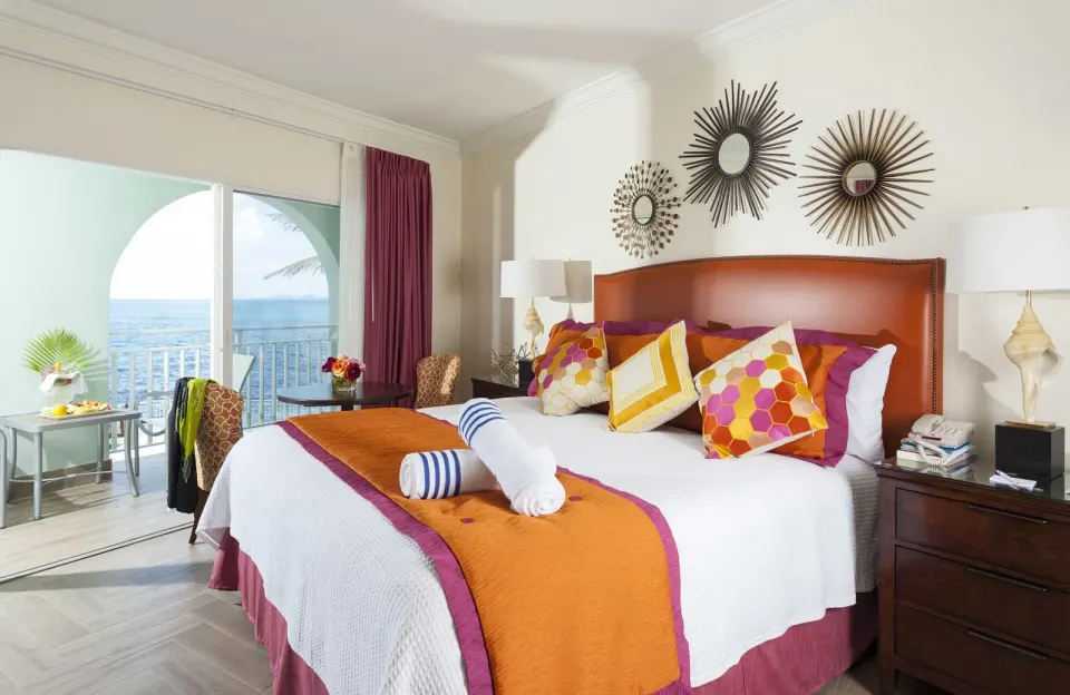 Ocean Front Courtyard Room king bed and balcony view at Oyster Bay Beach Resort.