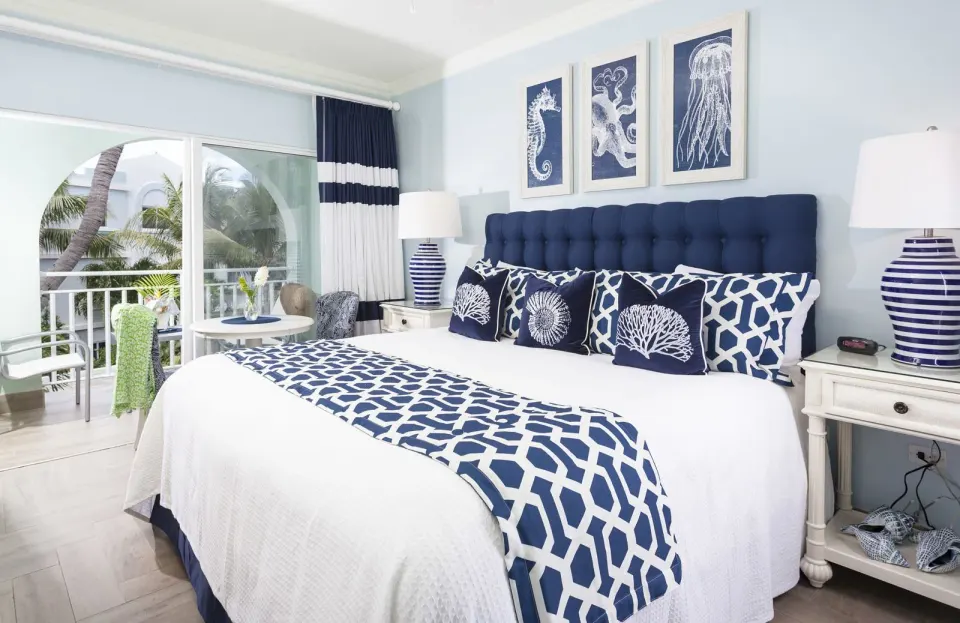 Premier Courtyard Room king bed and balcony doors at Oyster Bay Beach Resort.