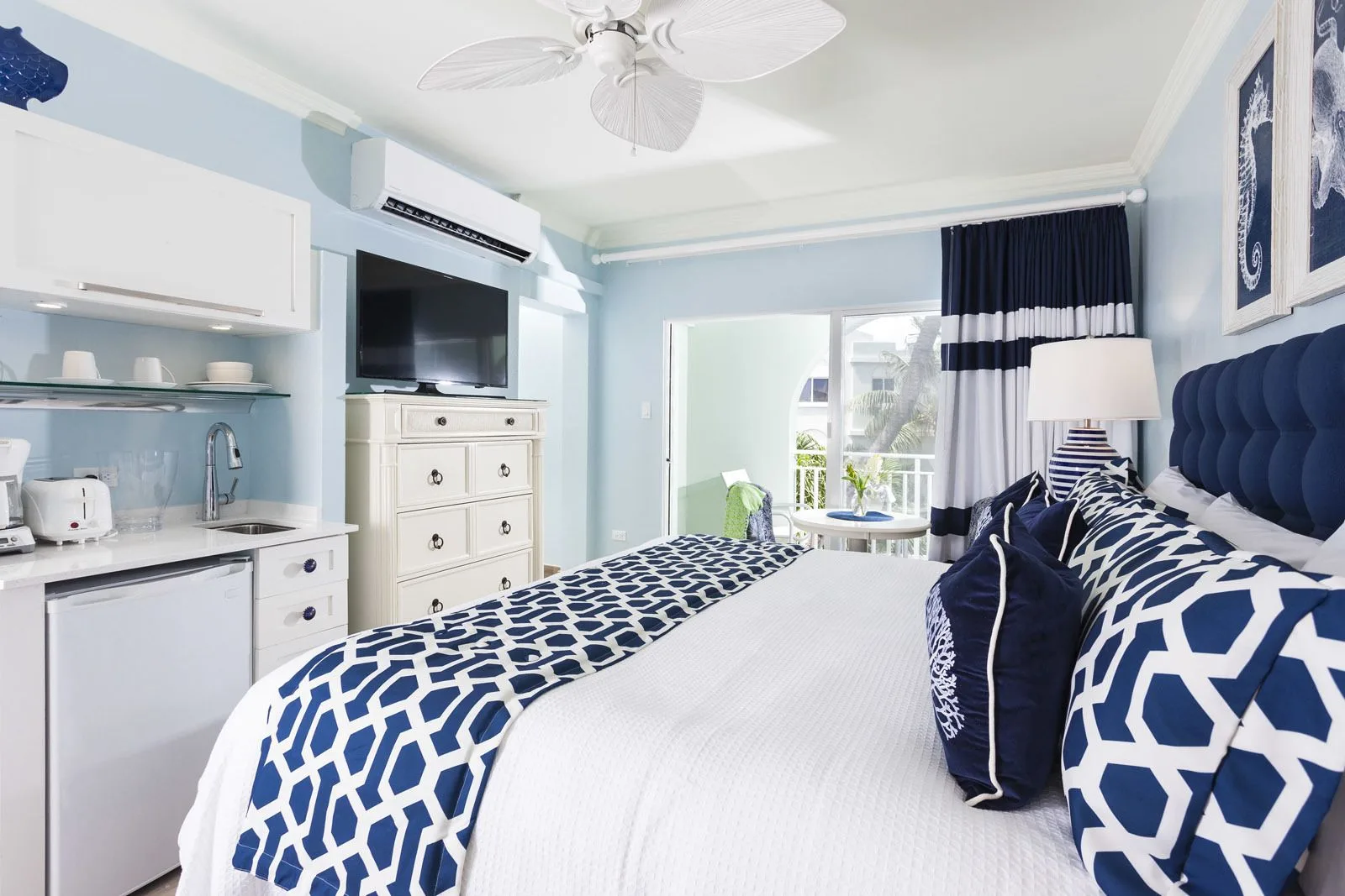 Premier Courtyard Room king bed and kitchenette at Oyster Bay Beach Resort.