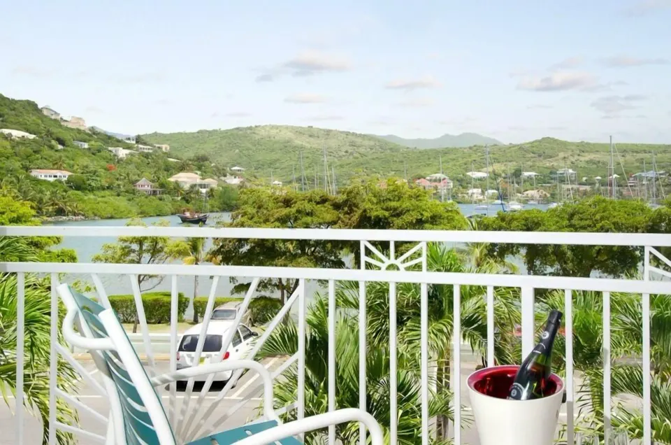 Studio balcony with chair, ice bucket, and marina hillside view at Oyster Bay Beach Resort.