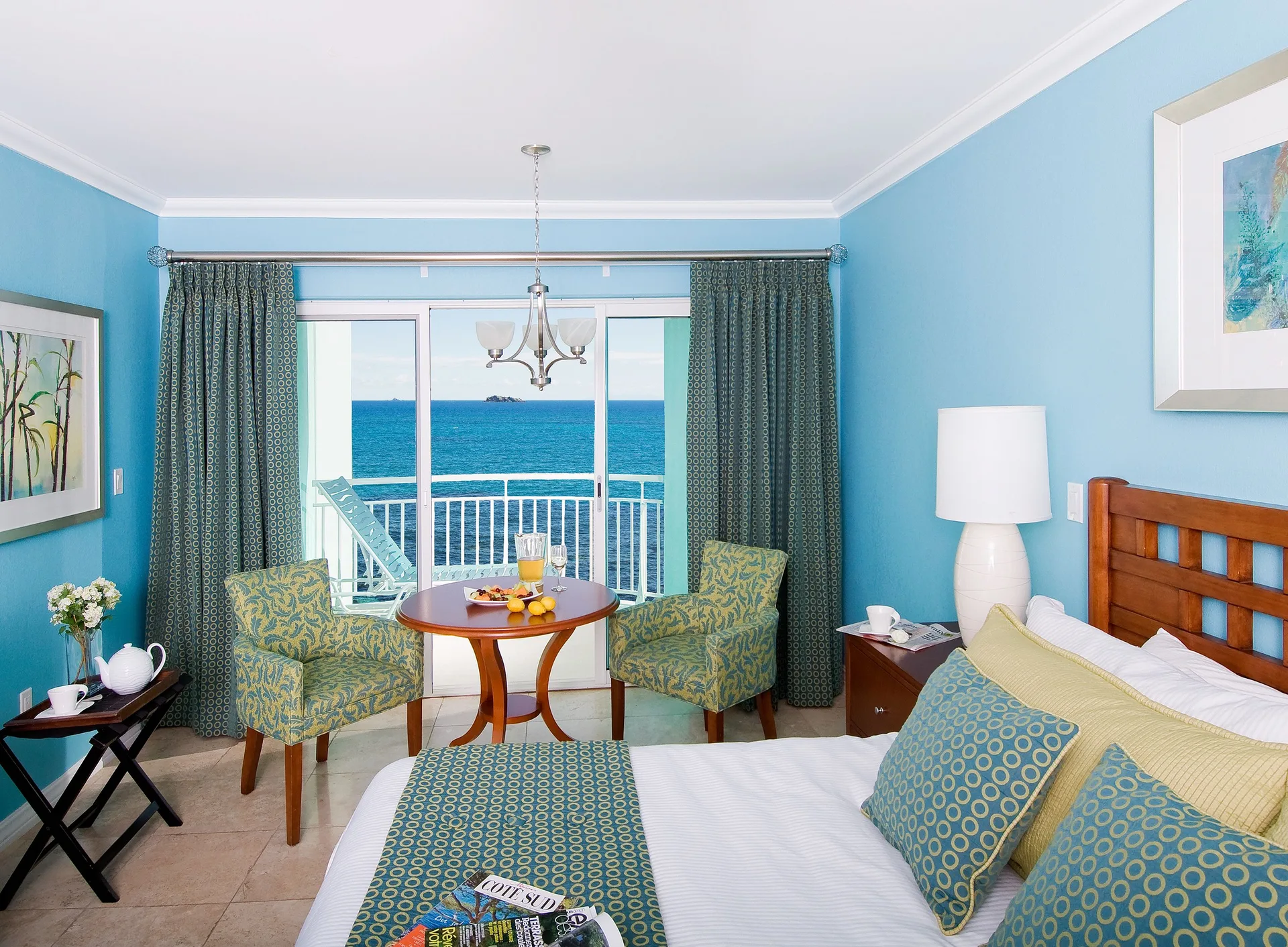 Oceanfront one-bedroom suite with king bed and balcony view at Oyster Bay Beach Resort.