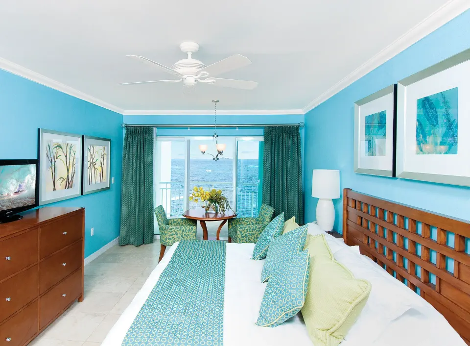 Oceanfront one-bedroom suite with king bed and sea-facing windows at Oyster Bay Beach Resort.