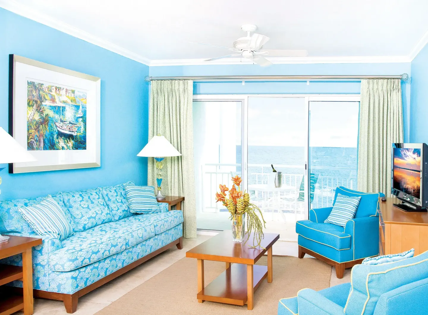 Oceanfront one-bedroom suite lounge with balcony doors at Oyster Bay Beach Resort.