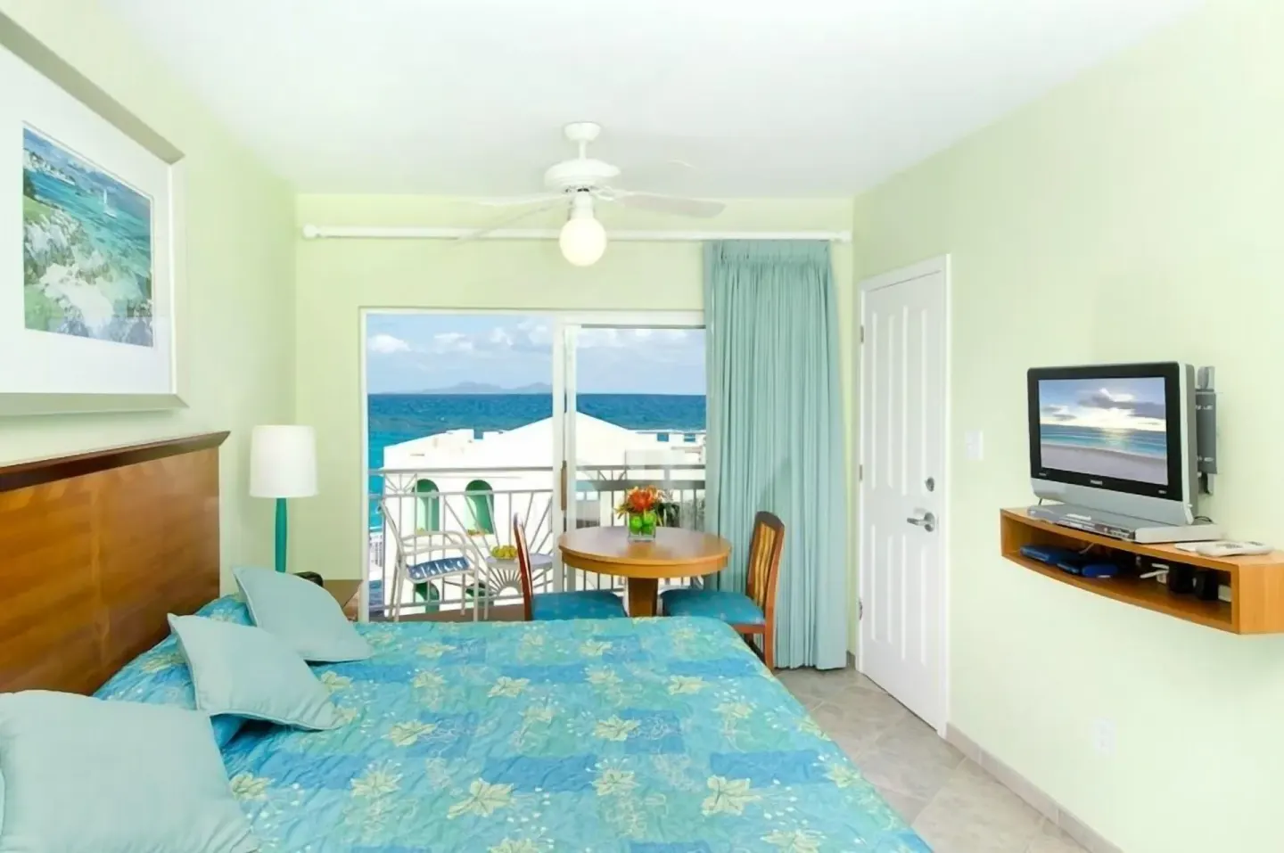 One-bedroom suite king bed with ocean-facing balcony at Oyster Bay Beach Resort.