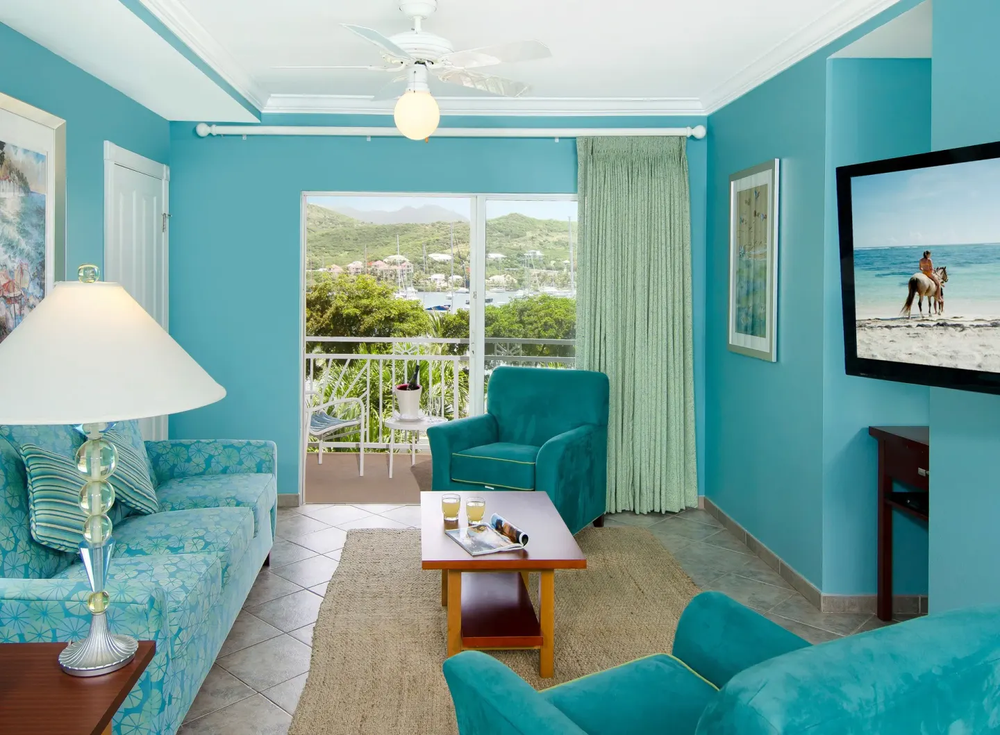 One-bedroom suite living room with balcony and marina view at Oyster Bay Beach Resort.