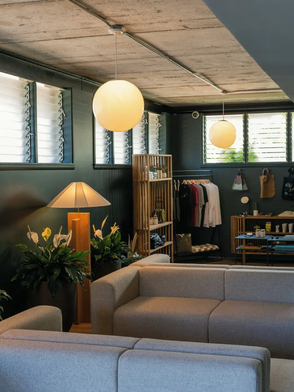 Close view of lobby seating, globe lights, plants, and merchandise displays at PACIFIC 19 Kona.