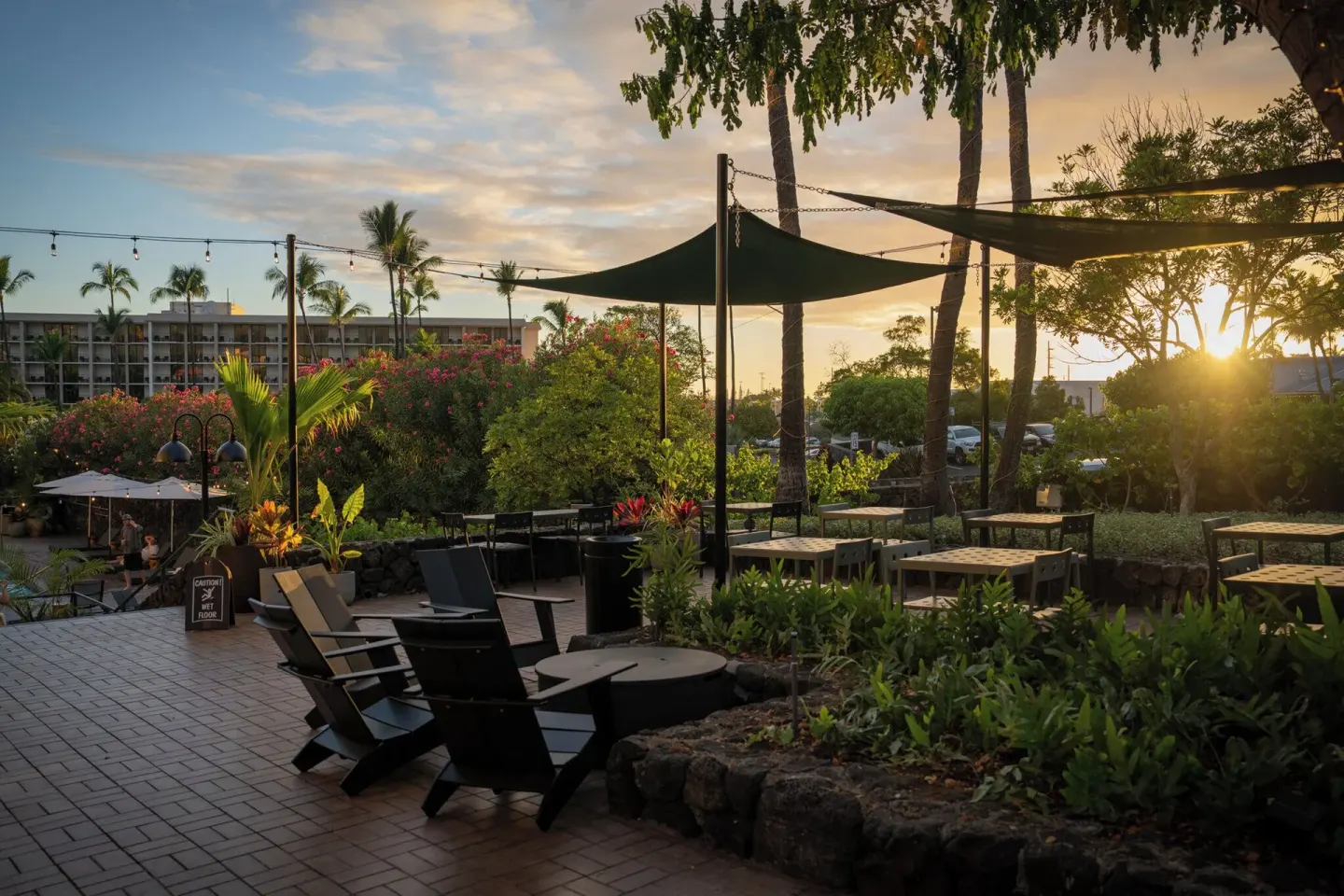 Sunset over the landscaped patio seating area at PACIFIC 19 Kona.