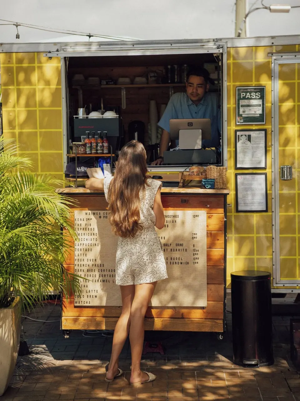 Guest ordering at a yellow coffee trailer at PACIFIC 19 Kona.