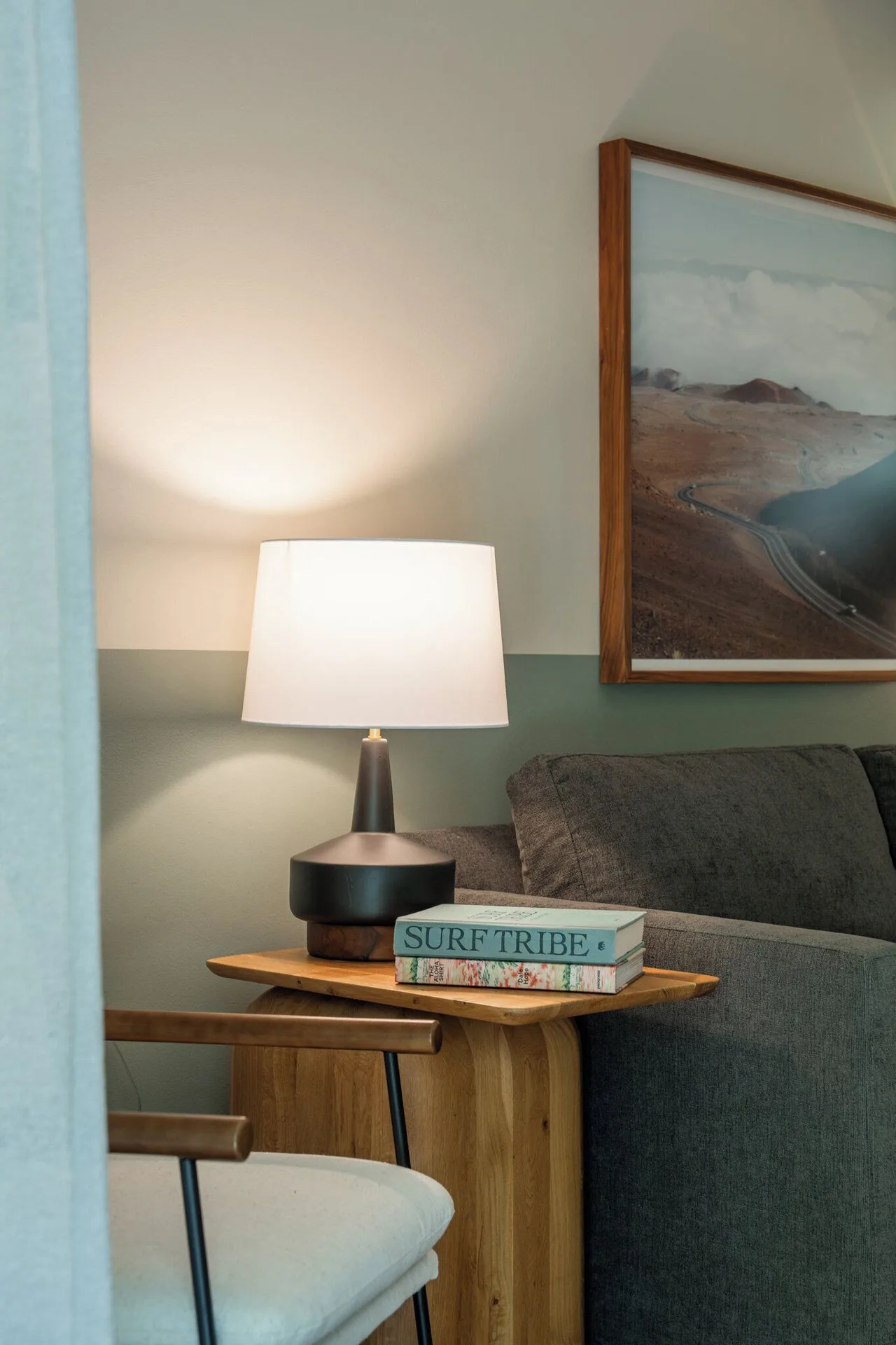 Apartment Suite seating nook with sofa, side table, lamp and framed coastal art at PACIFIC 19 Kona.