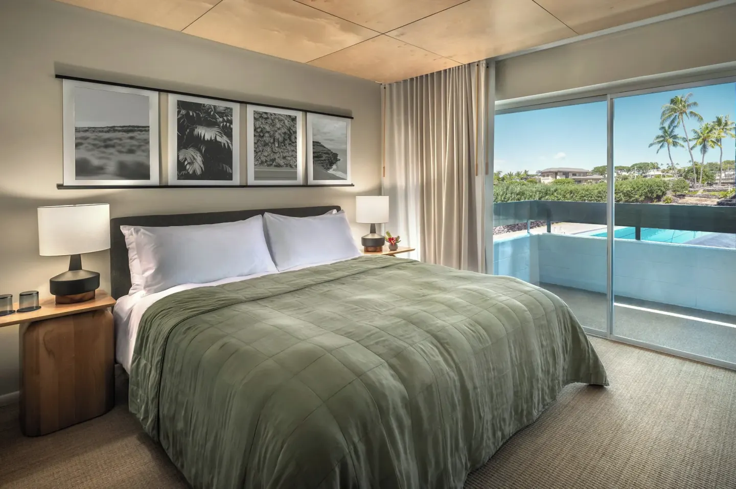 Pool View room king bed with balcony, pool, and palm trees at PACIFIC 19 Kona.