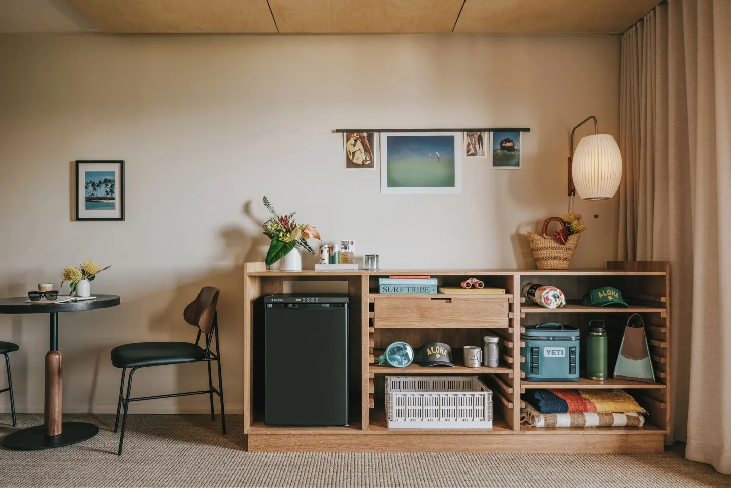 Guest room seating, mini fridge, and open shelving at PACIFIC 19 Kona.