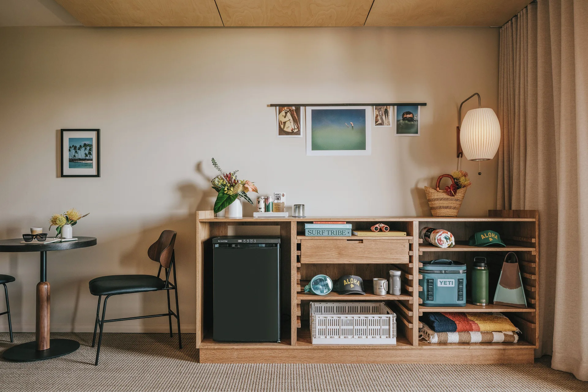 Guest room seating, mini fridge, and open shelving at PACIFIC 19 Kona.