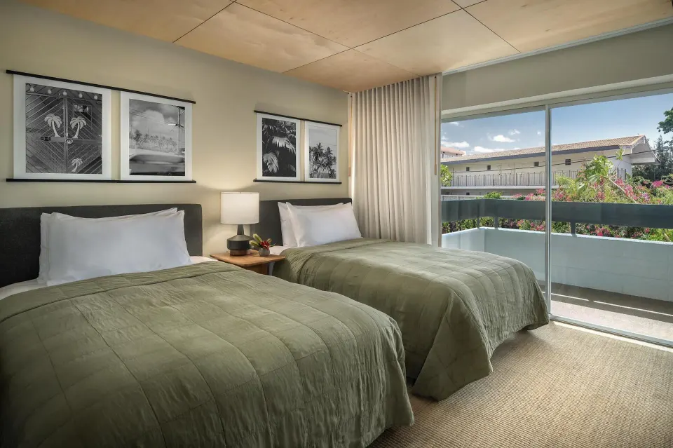 Two-bed guest room with balcony and tropical artwork at PACIFIC 19 Kona.