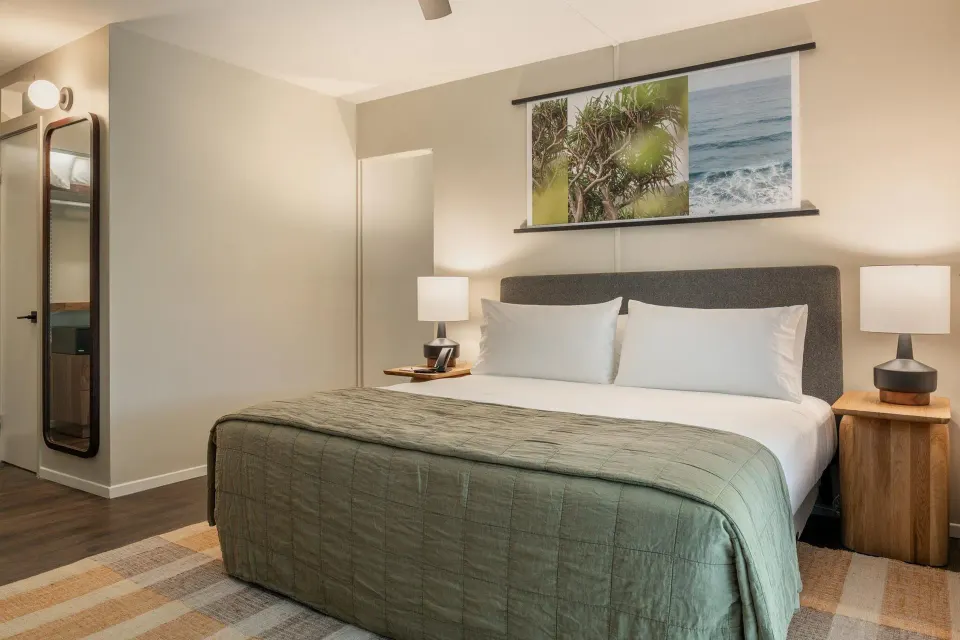 Suite Ohana king bed with lamps and wall art at PACIFIC 19 Kona.