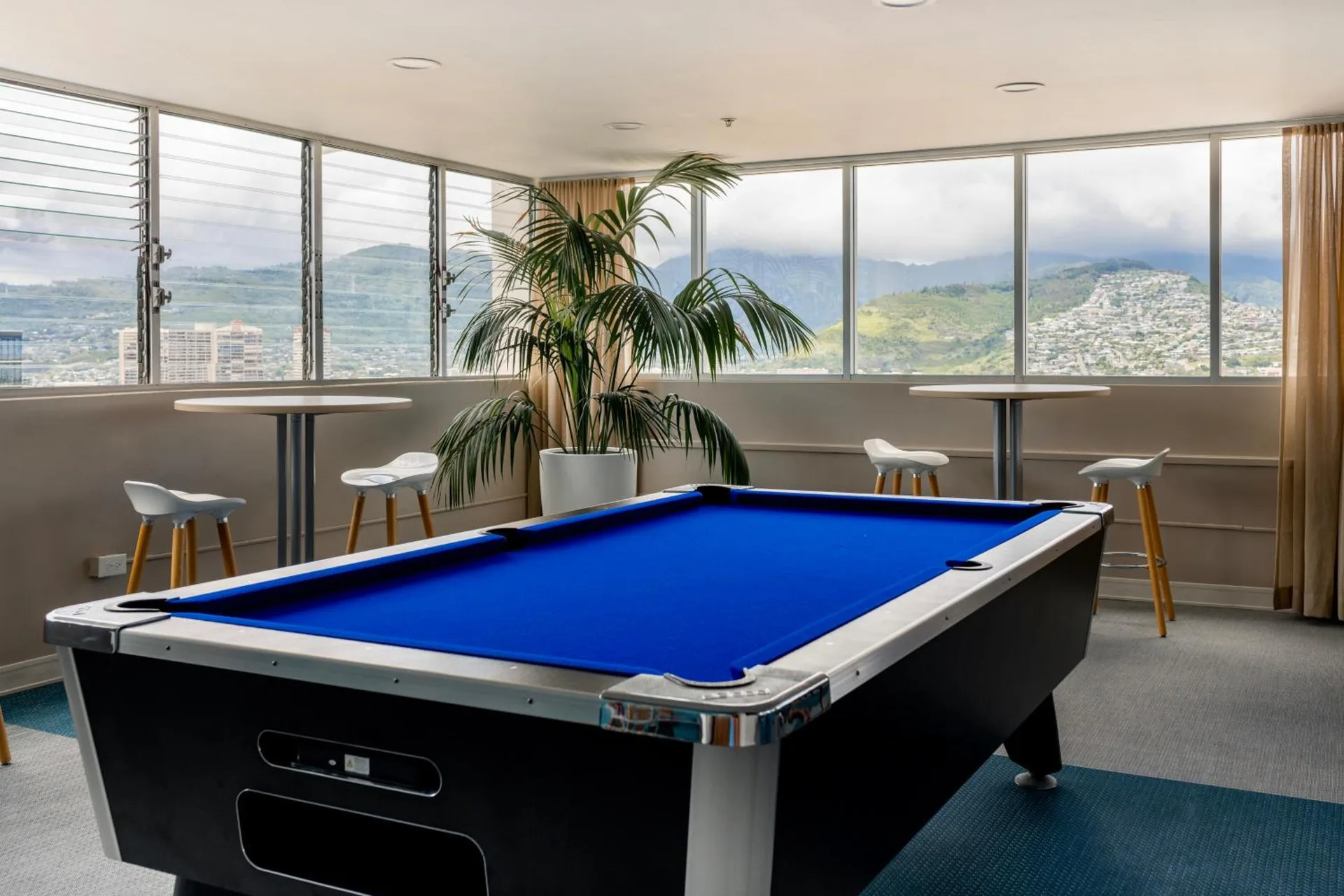Game room with a blue pool table and mountain views at Pacific Monarch Hotel.