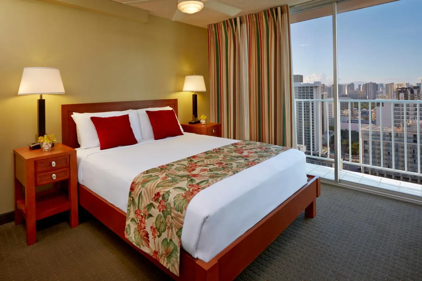 Guest room with king bed and city-view balcony at Pacific Monarch Hotel.