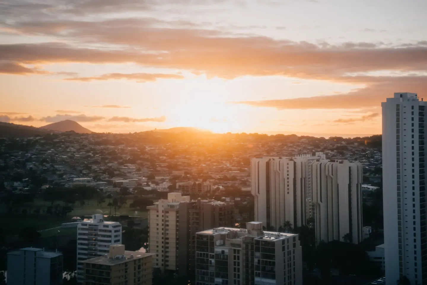 Sunset over Honolulu buildings and hills as seen from Pacific Monarch Hotel.