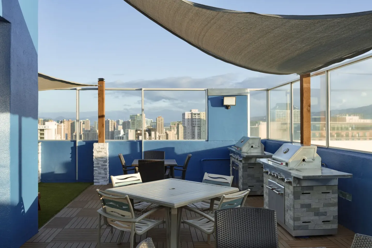 Rooftop barbecue area with tables and skyline views at Pacific Monarch Hotel.