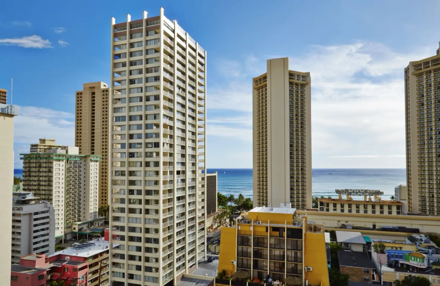 High-rise Waikiki buildings with ocean visible beyond them near Pacific Monarch Hotel.