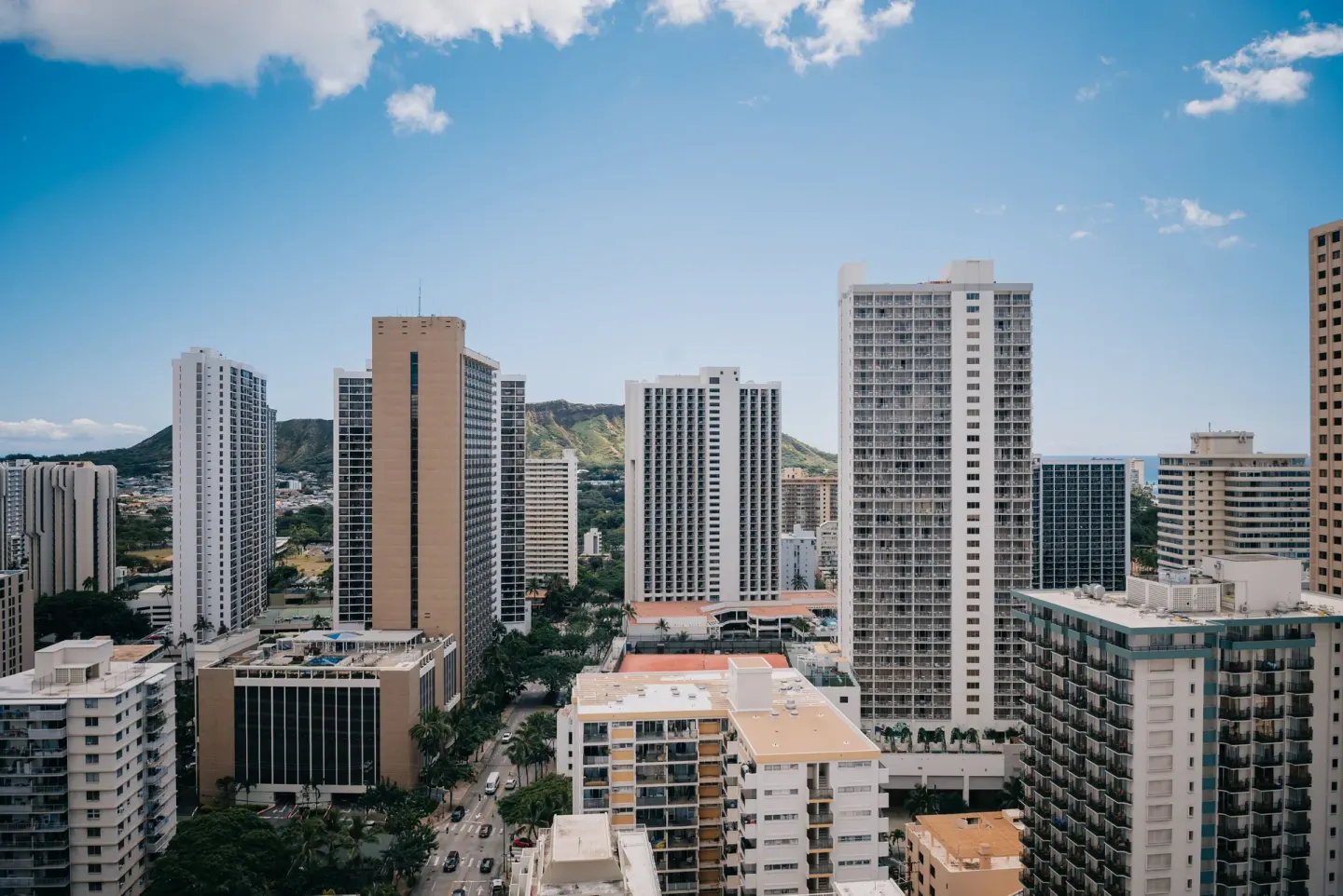 Waikiki skyline with tall buildings and glimpses of ocean from Pacific Monarch Hotel.