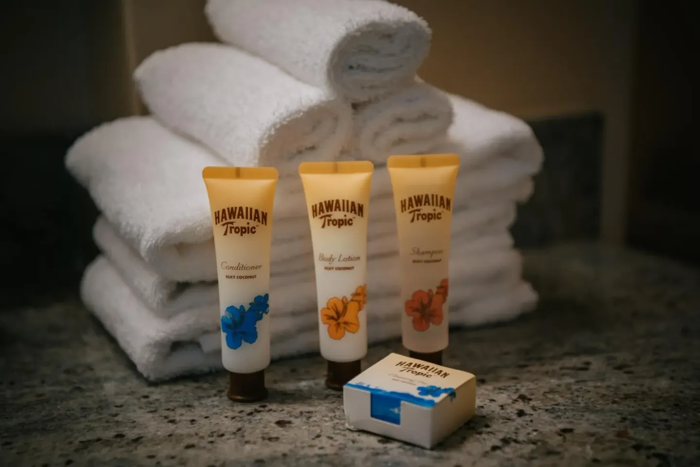 Folded towels and bath amenities on a vanity at Pacific Monarch Hotel.