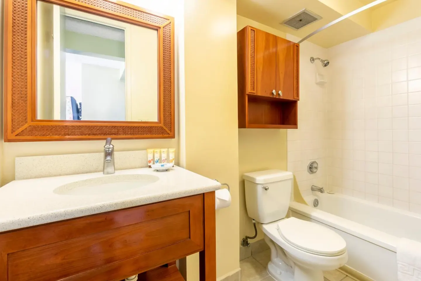 Bathroom with vanity, mirror, toilet, and tub-shower at Pacific Monarch Hotel.