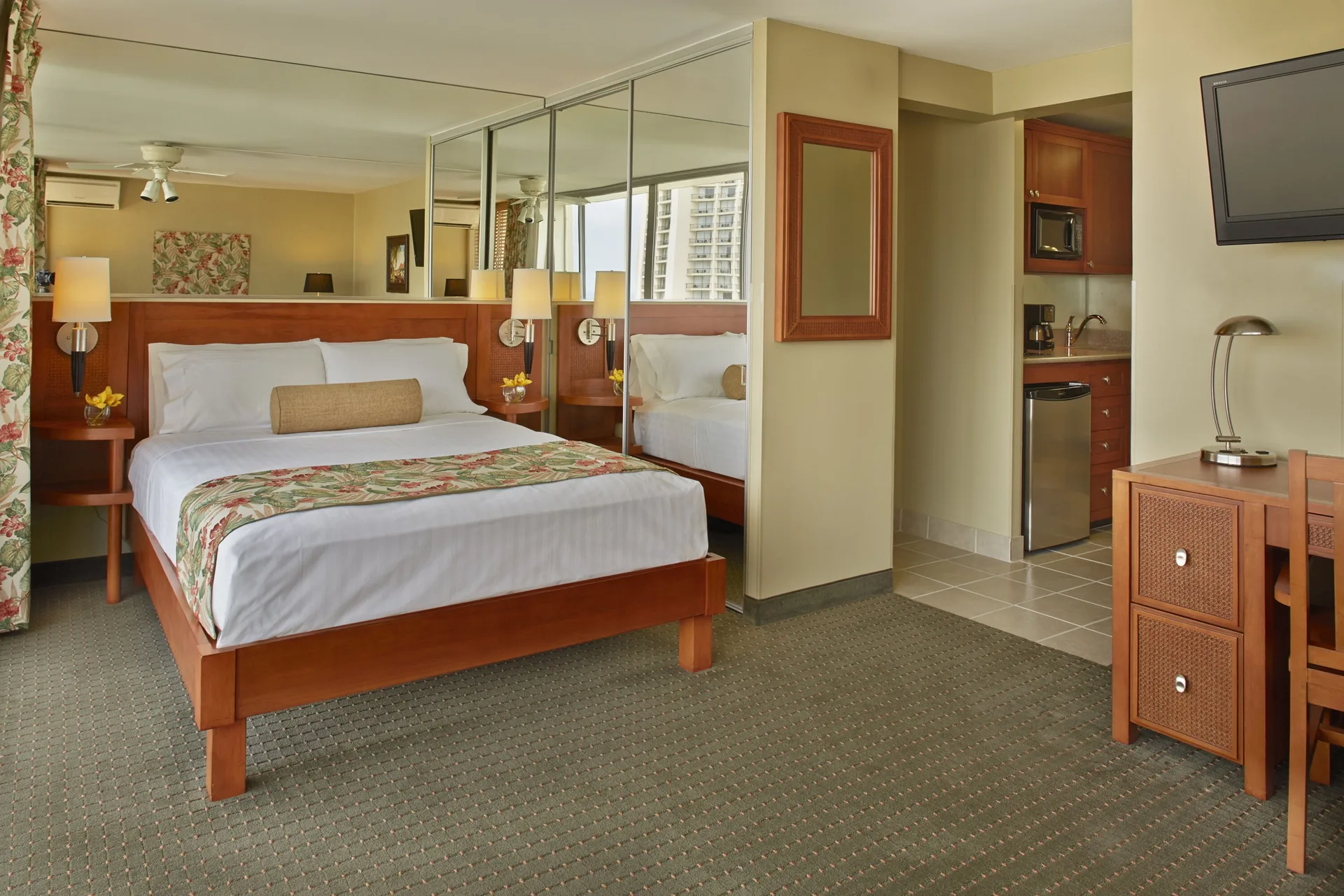 Studio Suite Partial Ocean View bed and kitchenette at Pacific Monarch Hotel.