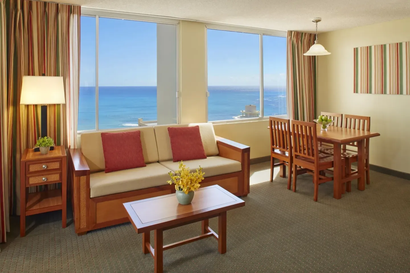 One-bedroom ocean-view suite seating and dining area at Pacific Monarch Hotel.