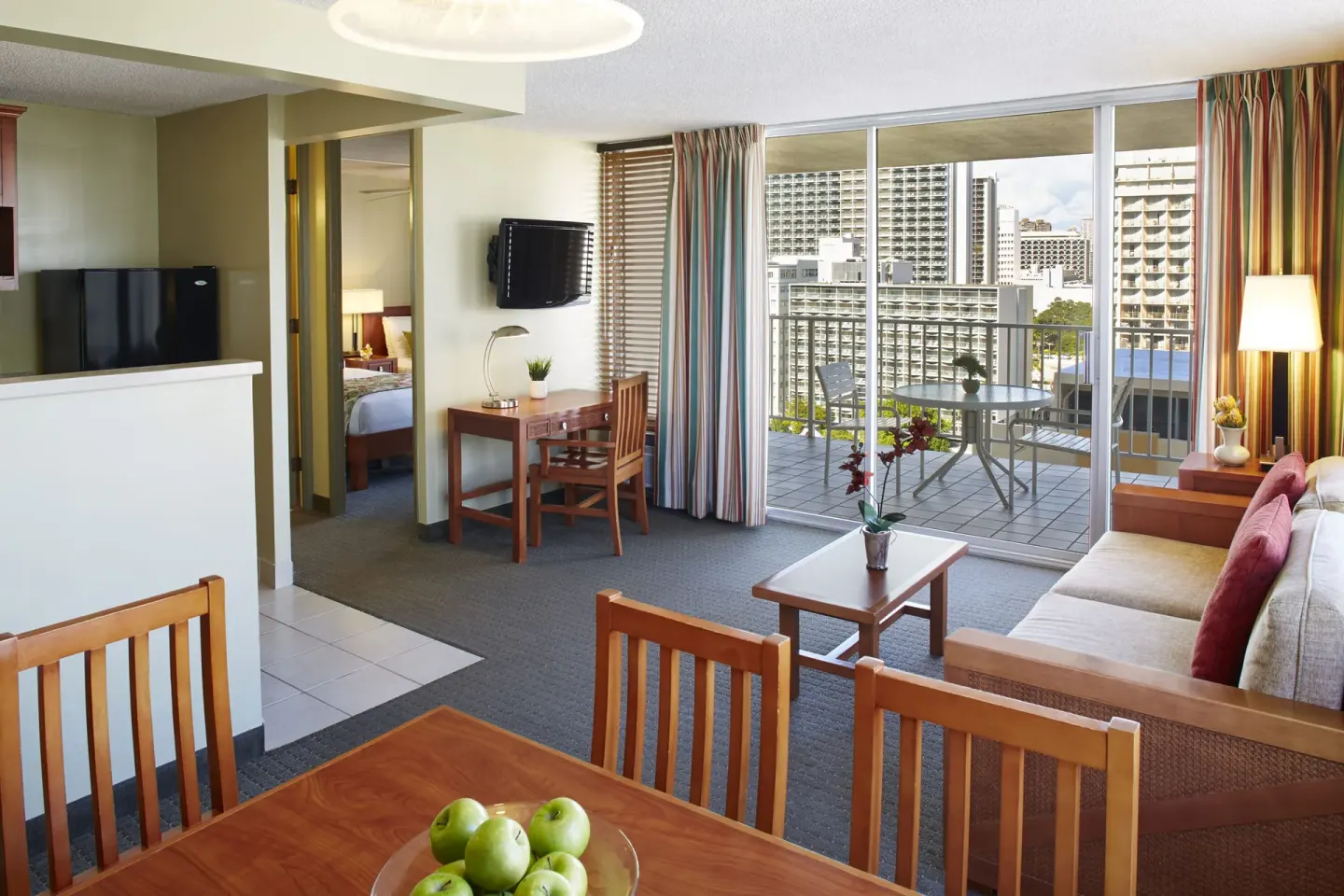 One-bedroom partial ocean view suite living area with balcony at Pacific Monarch Hotel.
