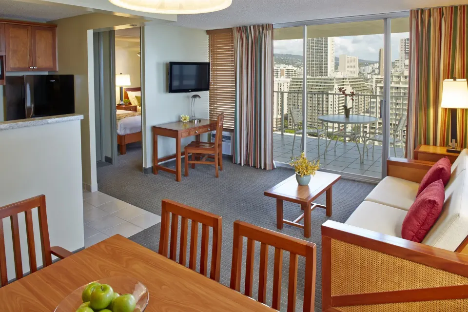 One-bedroom suite living and dining area with kitchenette at Pacific Monarch Hotel.