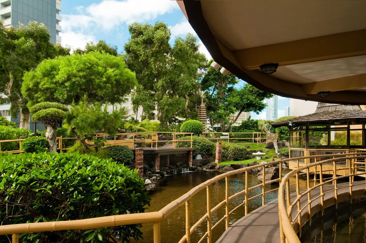 Garden walkways, pond, bamboo railings, and pavilion at Pagoda Hotel.