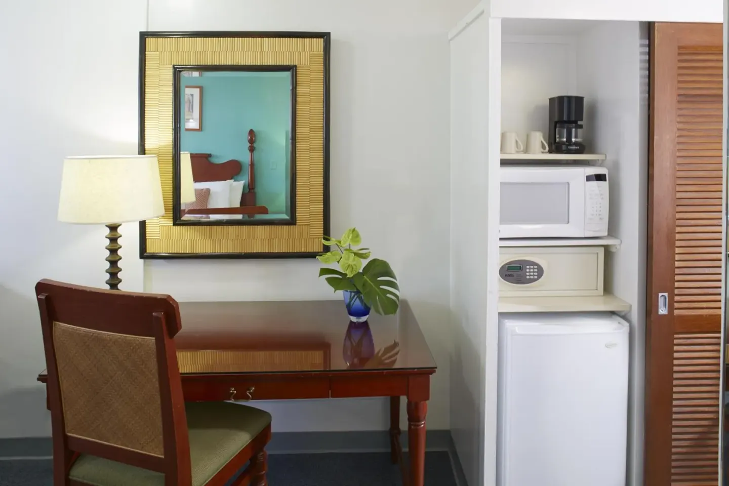Guest room desk, mirror, and appliance nook at Pagoda Hotel.