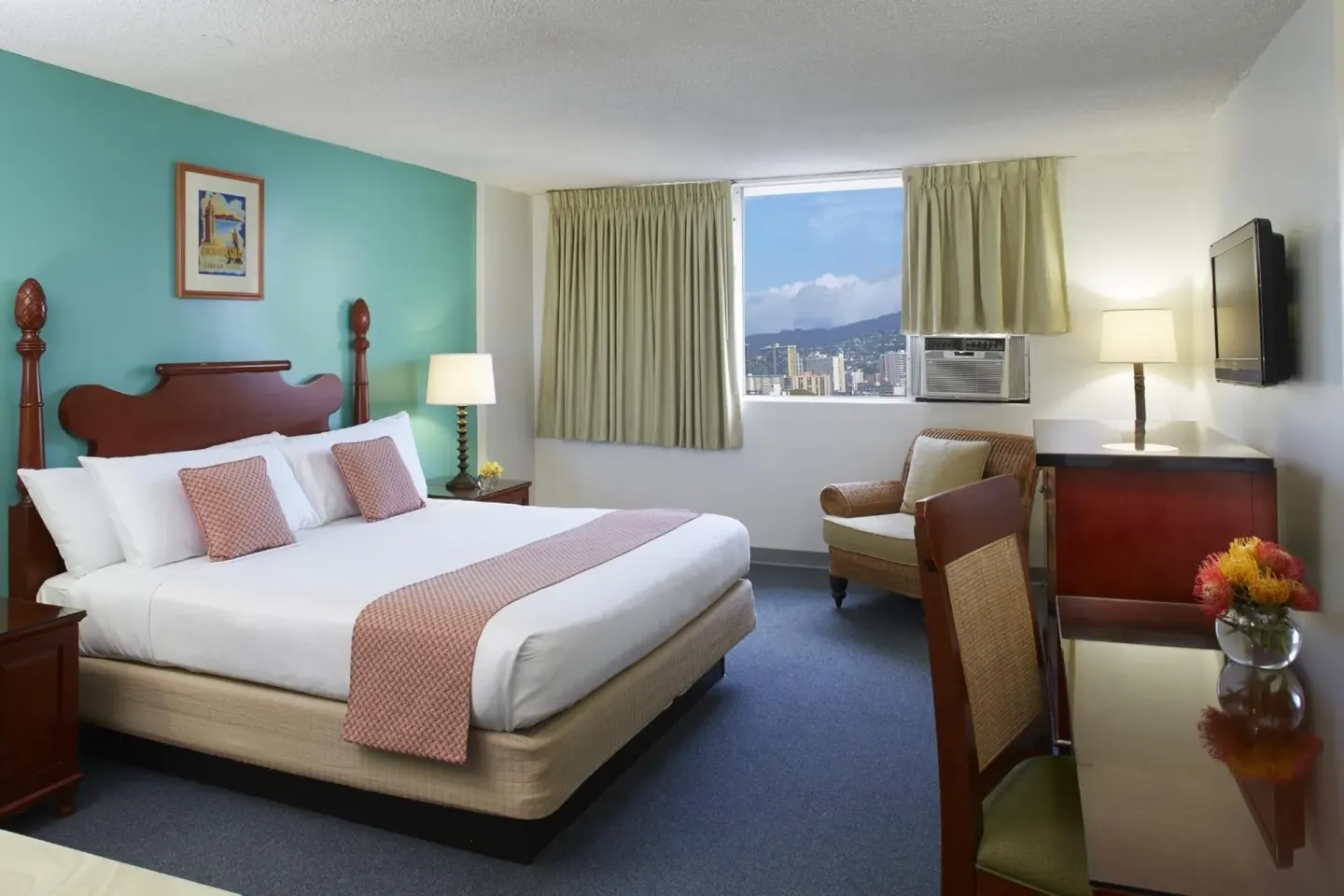 Guest room with king bed, chair, desk, TV and city view window at Pagoda Hotel.