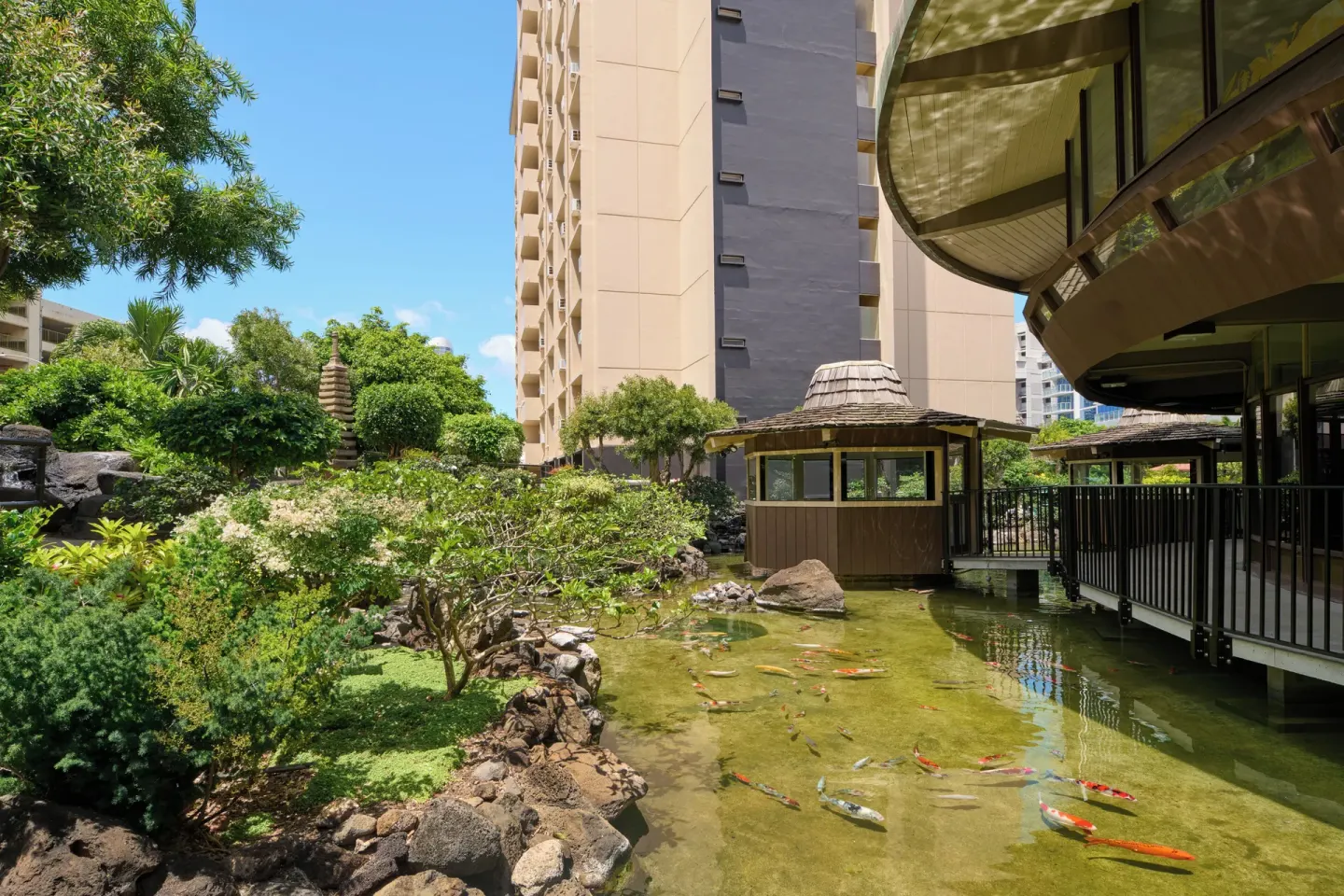 Koi pond, garden path, and hotel tower beside the restaurant at Pagoda Hotel.