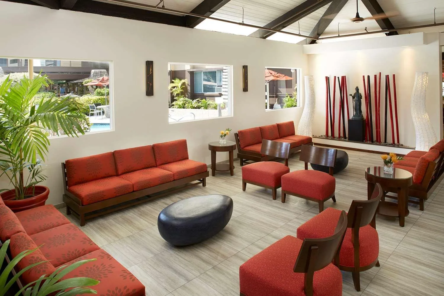 Lobby lounge with red seating and garden windows at Pagoda Hotel.