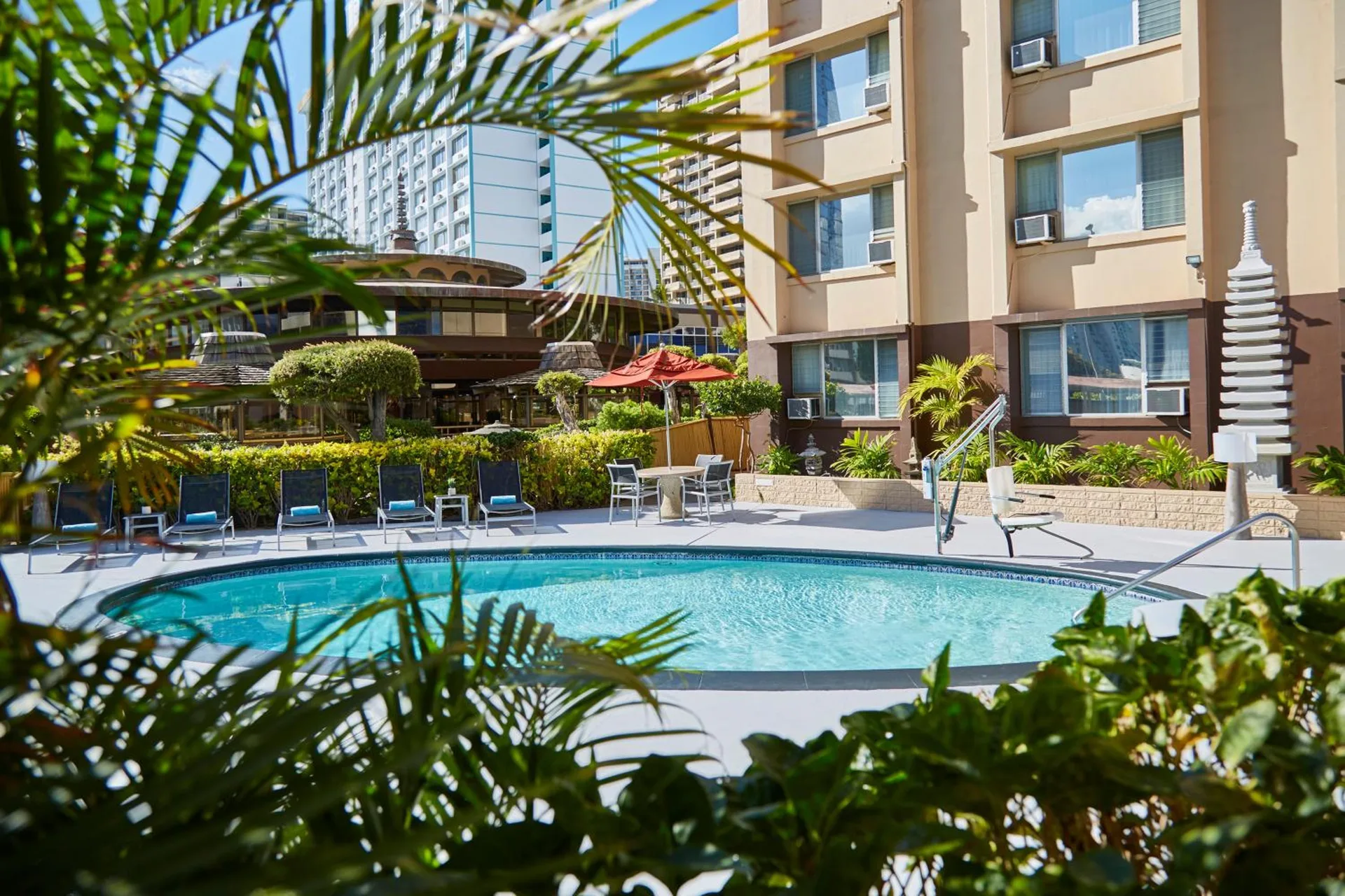 Outdoor pool with lounge chairs and hotel buildings at Pagoda Hotel.