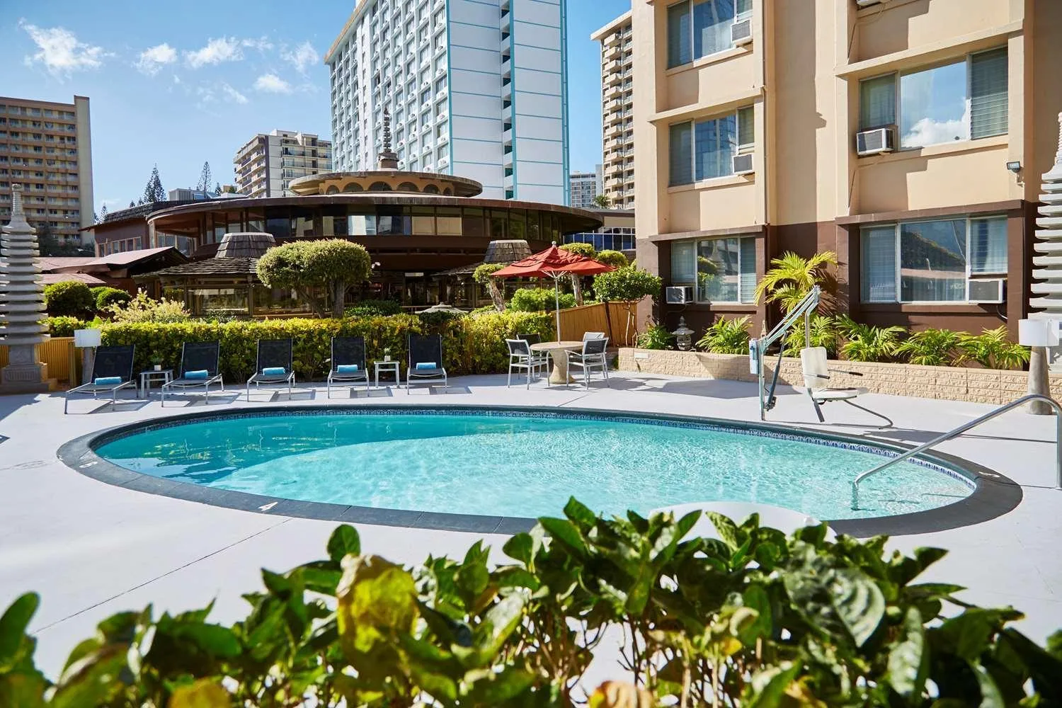 Outdoor pool deck with lounge chairs at Pagoda Hotel.