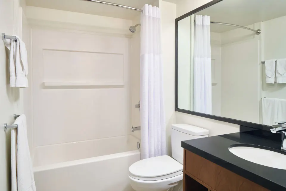City View room bathroom with tub, shower curtain, vanity, mirror, and towels at Pagoda Hotel.