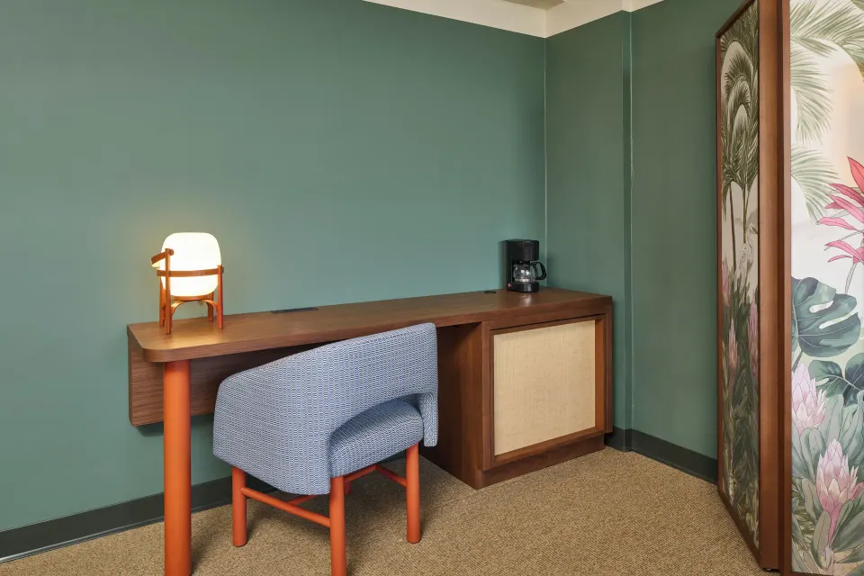 City View room desk with chair, lamp, coffee maker, and tropical screen at Pagoda Hotel.