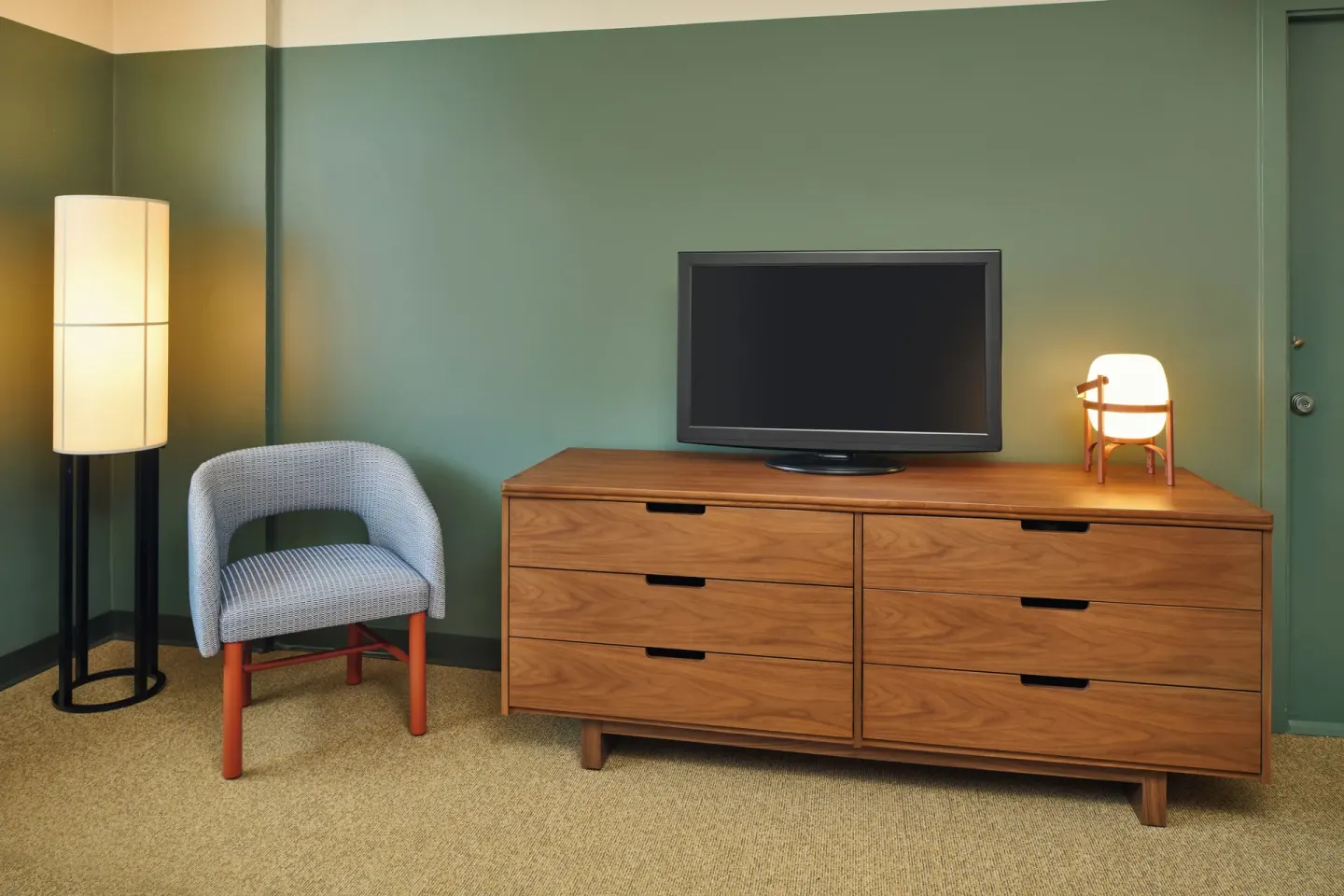 City View room dresser with television, chair, and floor lamps at Pagoda Hotel.