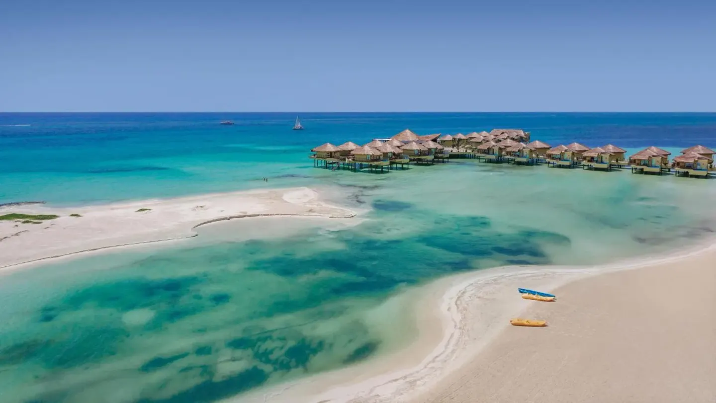 Aerial view of sandbars, kayaks, and overwater bungalows at Palafitos Overwater Bungalows.