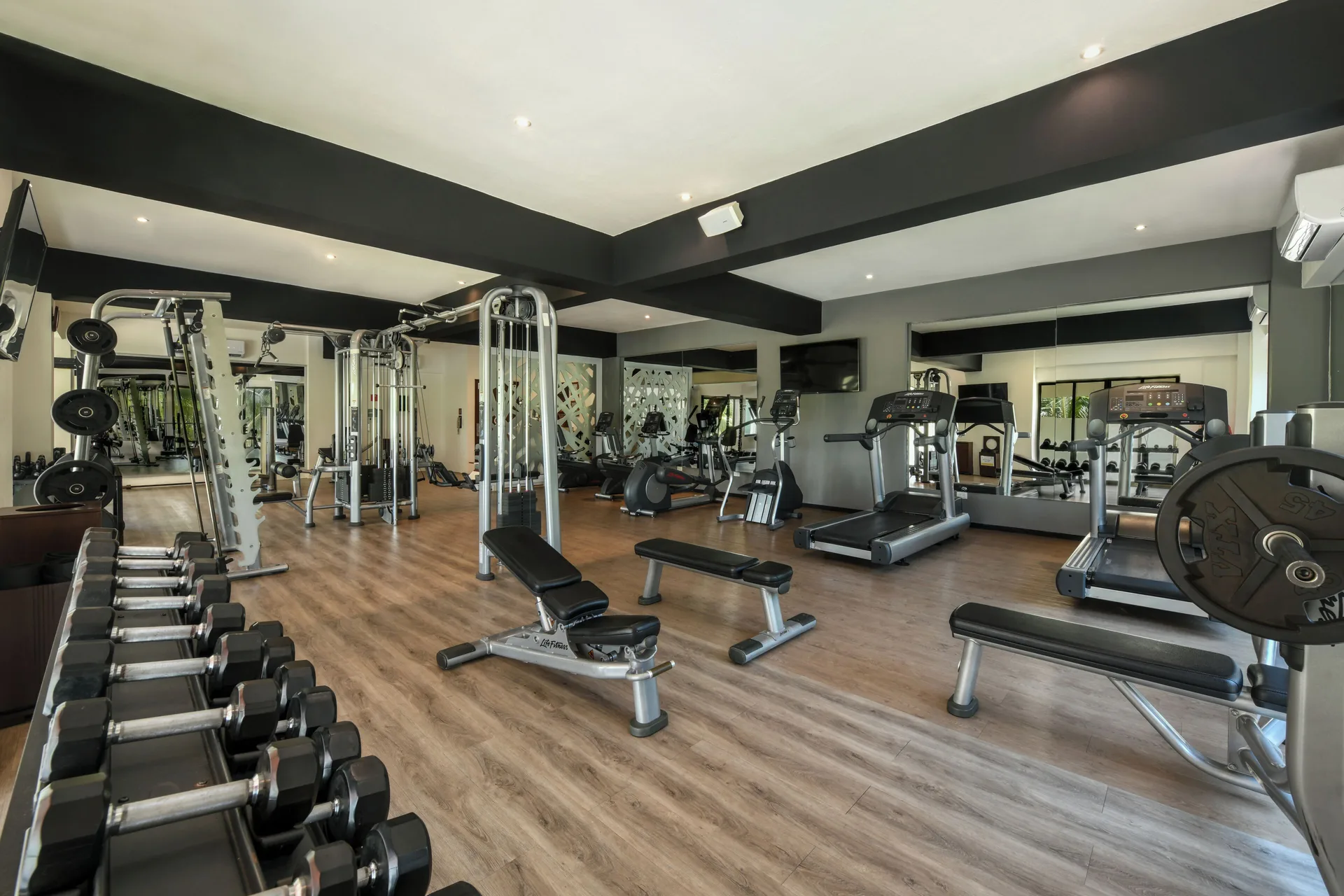 Fitness center with treadmills, weights and benches at Palafitos Overwater Bungalows.