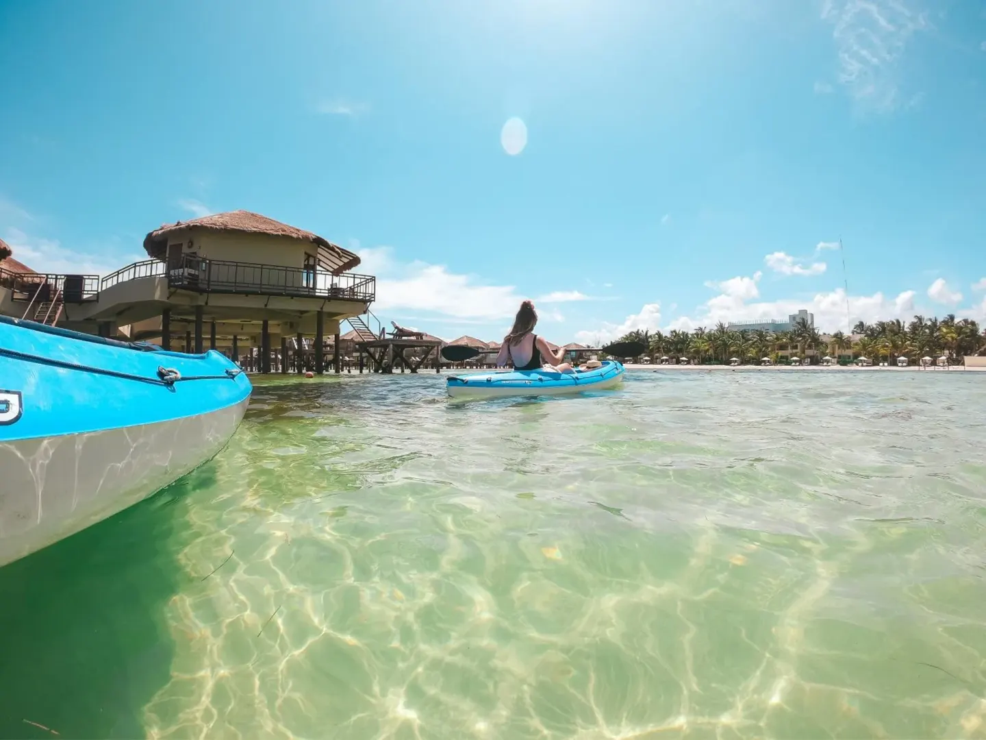Kayaks on clear shallow water near Palafitos Overwater Bungalows.