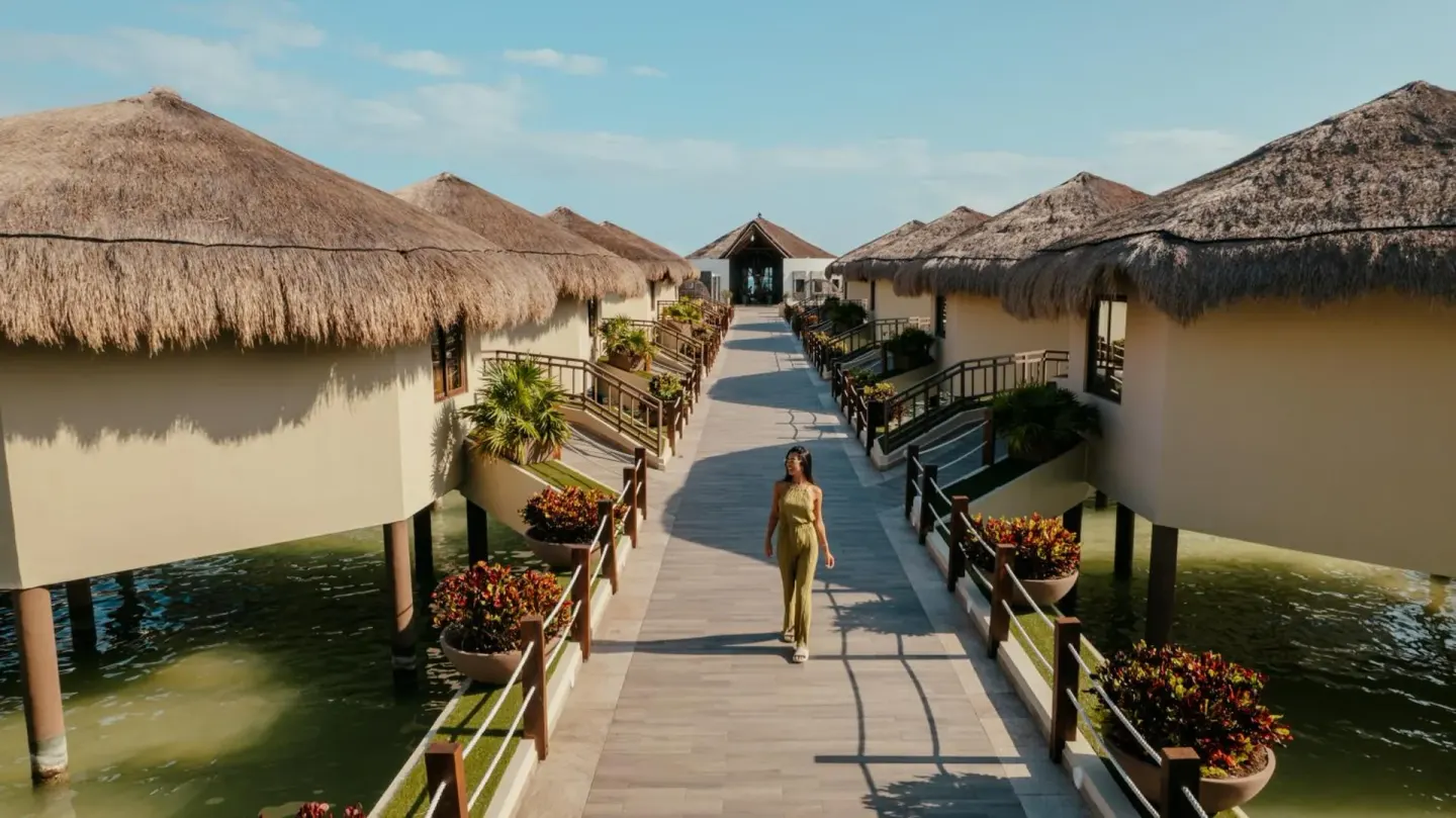 Guest walking the overwater bungalow boardwalk at Palafitos Overwater Bungalows.