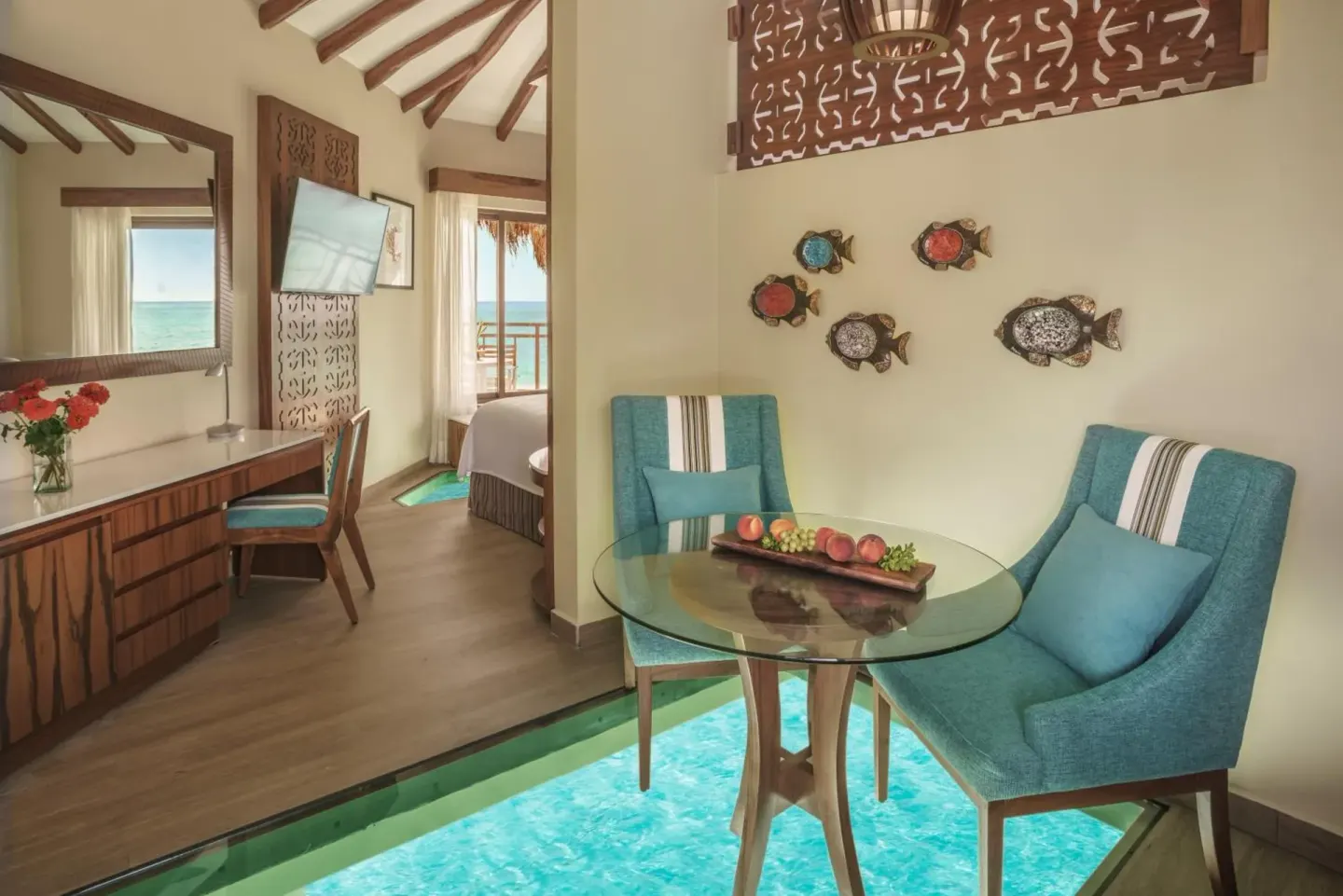 Sitting area with glass floor panels in a bungalow at Palafitos Overwater Bungalows.
