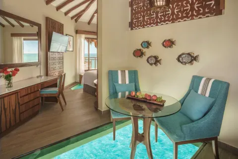 Sitting area with glass floor panels in a bungalow at Palafitos Overwater Bungalows.